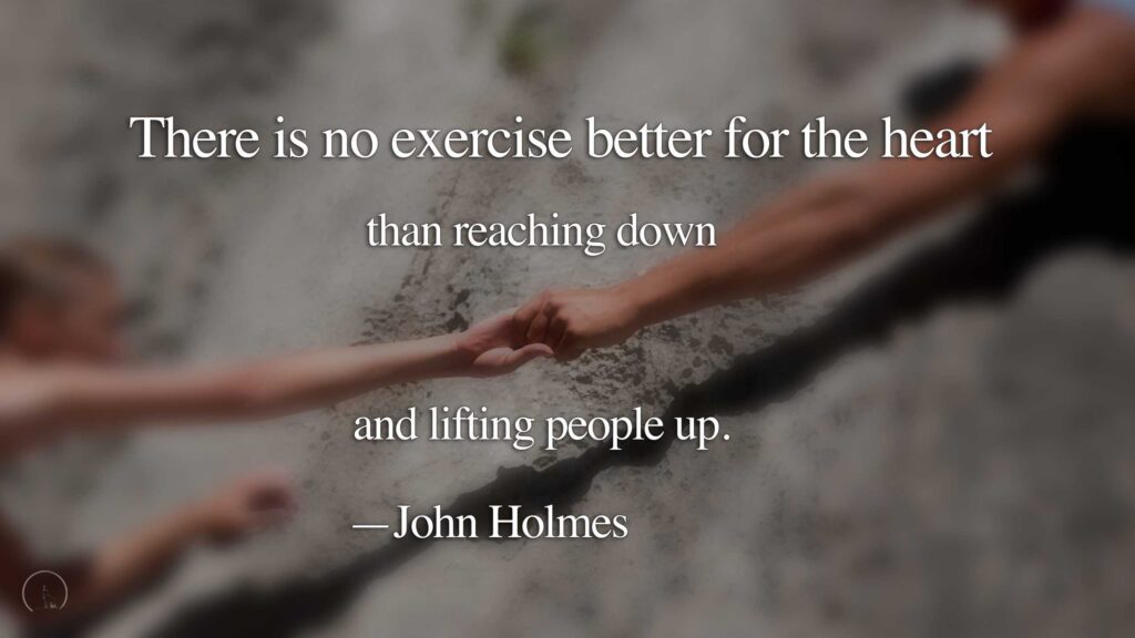 Two people grasping hands against a cliff face, text overlay: There is no exercise better for the heart than reaching down and lifting people up. —John Holmes